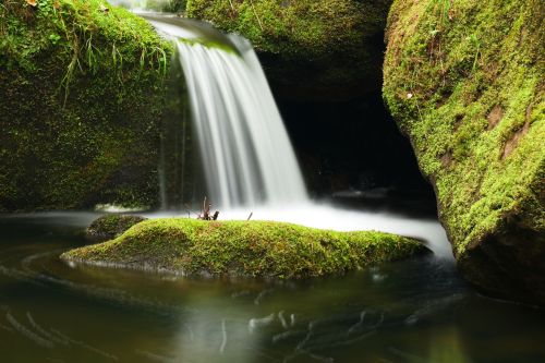 47642620 - cascade on small mountain stream. cold crystal water is falling over mossy boulders into small pool.